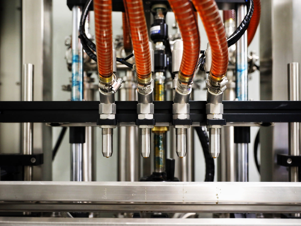Honey filling nozzles on a custom packing line sourced by TL Enterprises